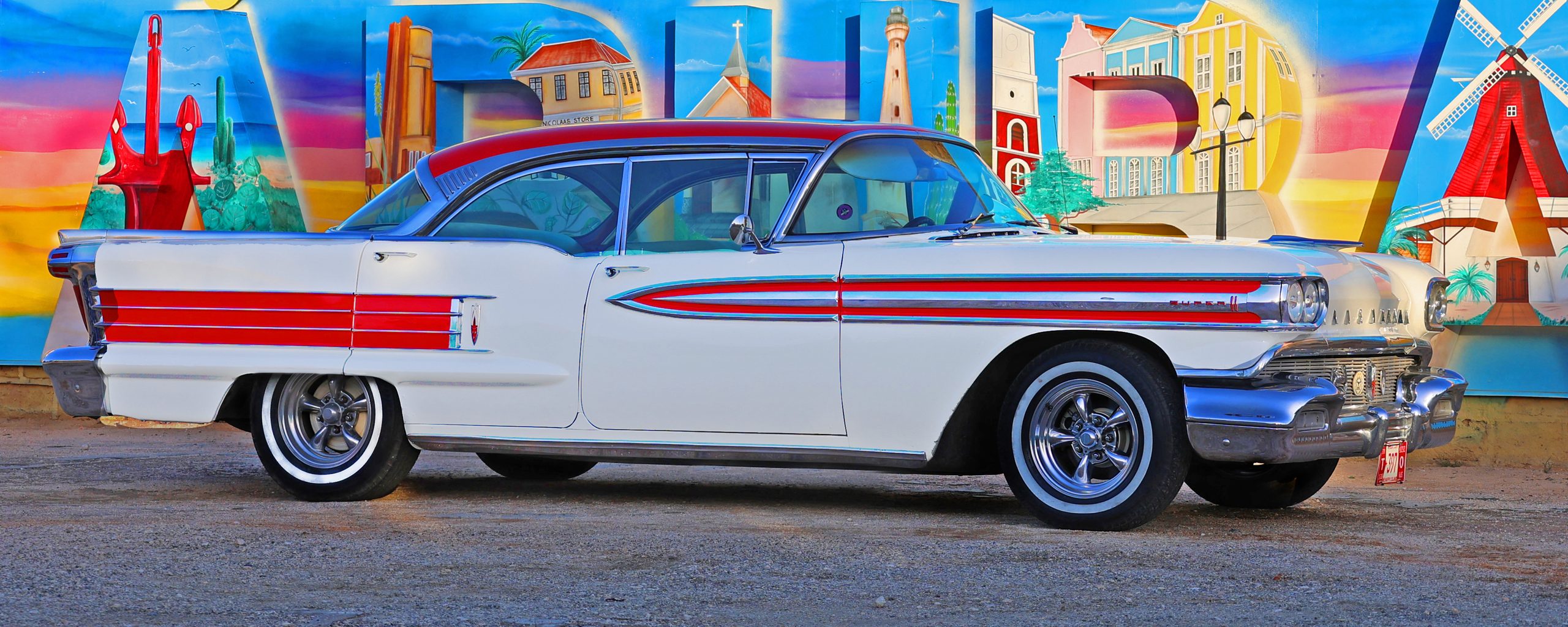 Classic Oldsmobile in front of the Aruba mural